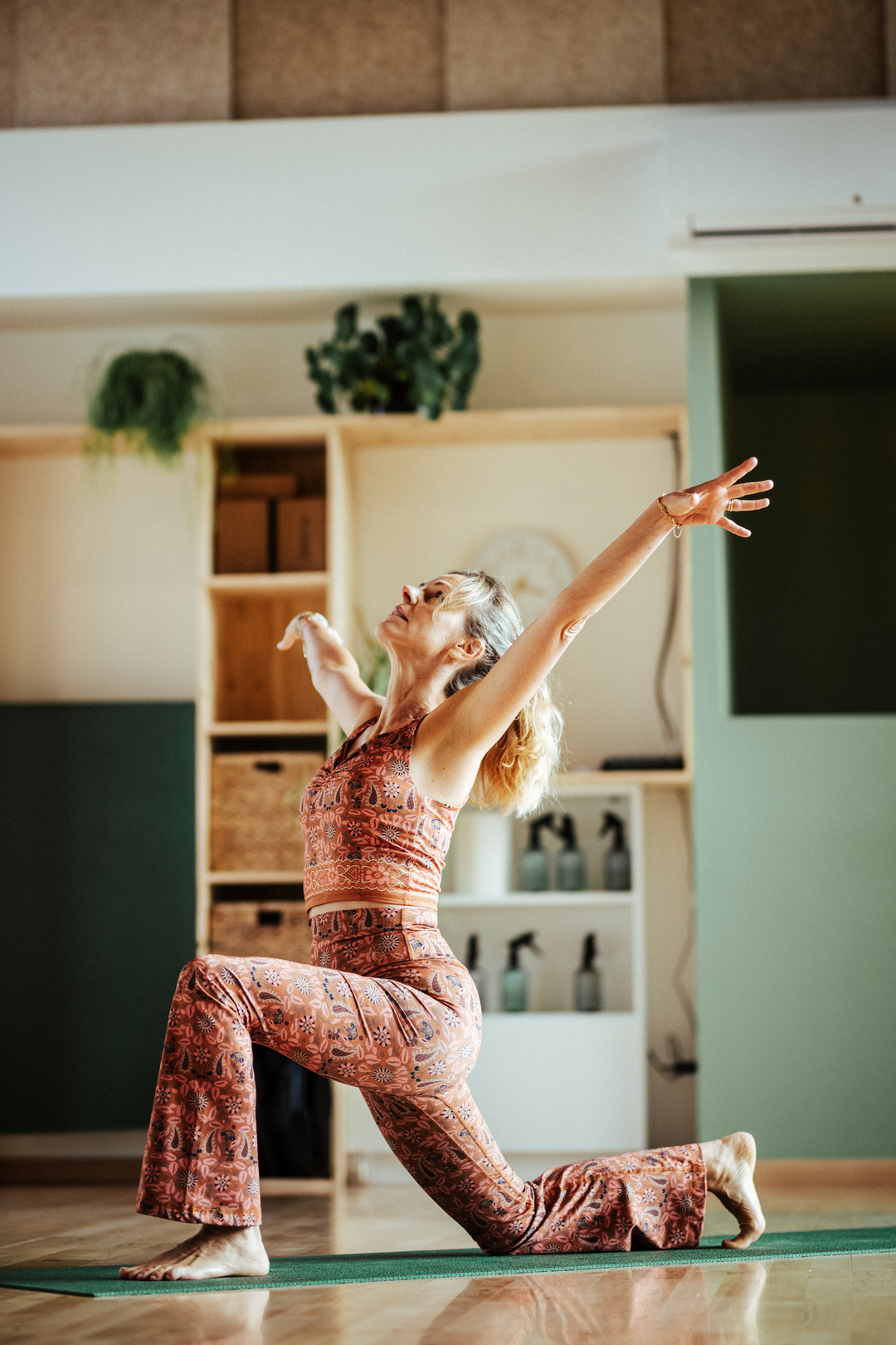 une personne en posture de yoga dansé dit Inside flow sur une tapis de yoga dans une salle chaleureuse : le Cerisier à Bailleul